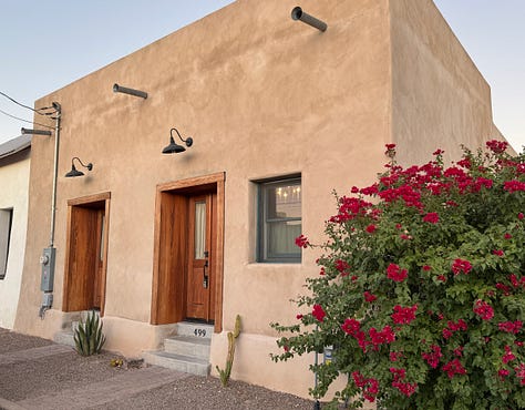 The photos display nine homes in the Sonoran architectural style traditional to the Southwest of the United States. The homes feature flat roofs, front walls that begin at the sidewalk's edge, colorful stucco exterior walls, and large windows.