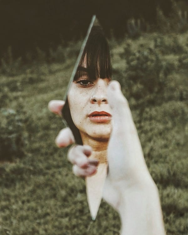 Woman Holding Broken Mirror