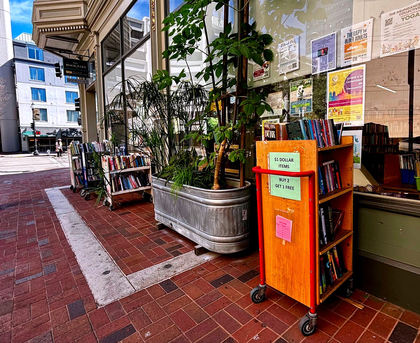 Outdoor displays of books capitalize on robust foot traffic and help draw passersby into The Bookmark. (Image source: Oakland Report)