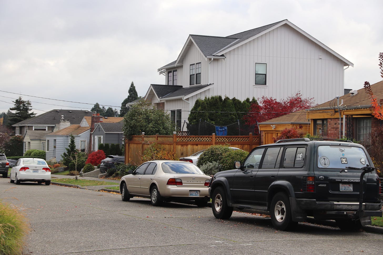 A large luxury house towers above a street of modest cottages that used to sell for little