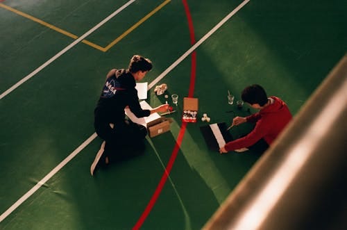 Free Anonymous men painting marking lines on sports court Stock Photo