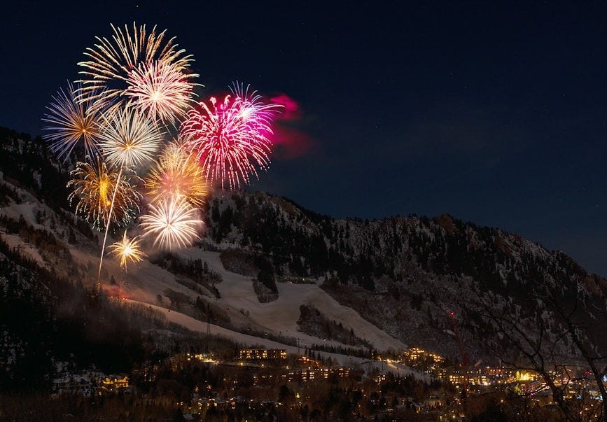 fireworks display from snow capped mountain during nighttime fireworks display from snow capped mountain during nighttime
