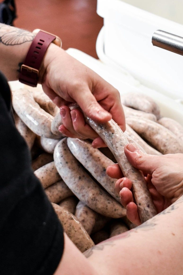 a person holding a bunch of sausages in their hands