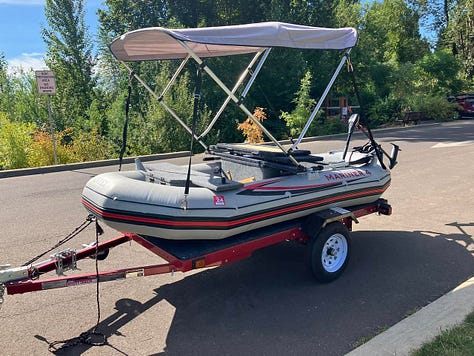 Red kayak in river, orange kayak tip, two kayers, yellow Malibu Two kayak
