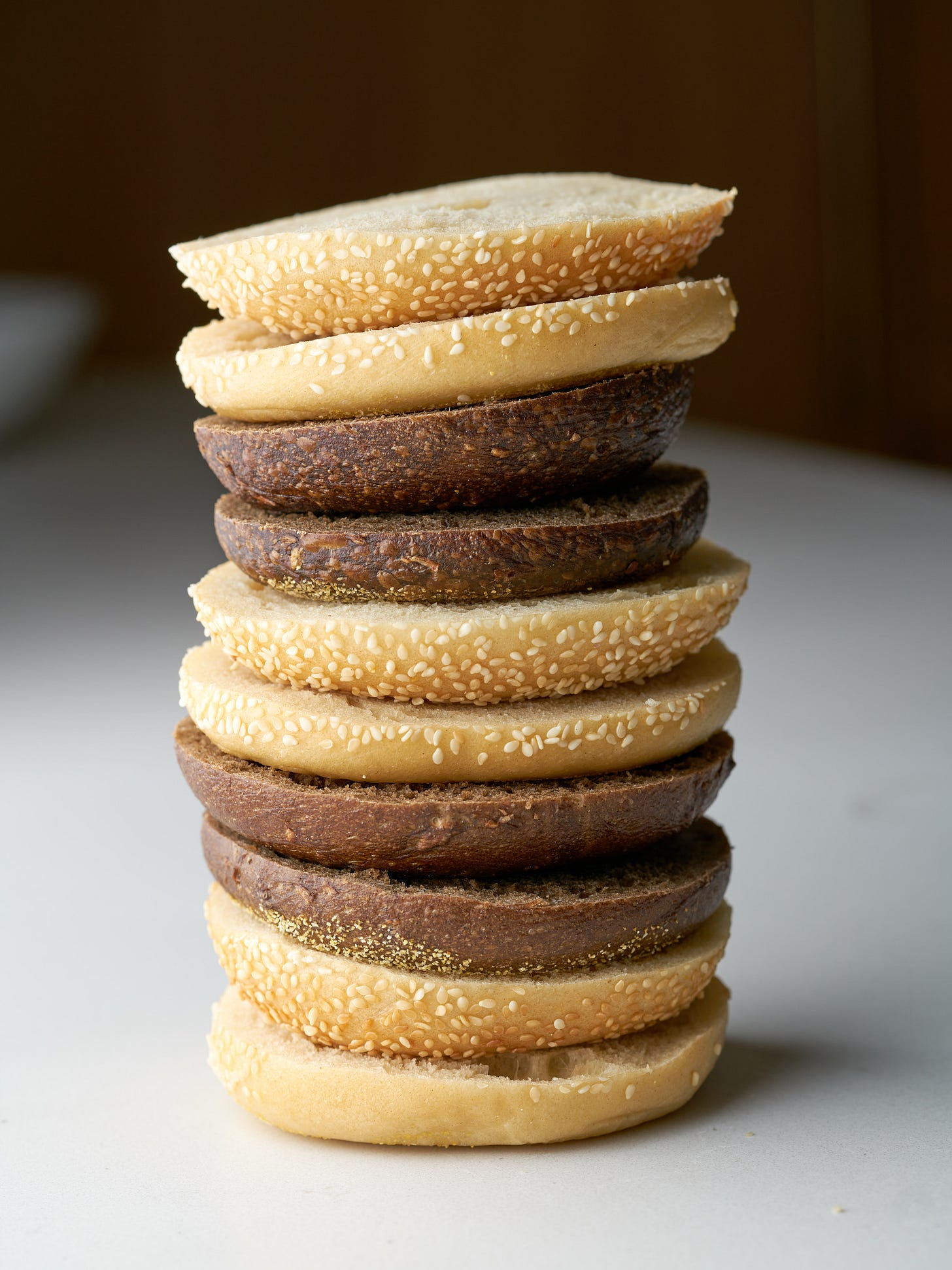 A tower of bagel slices alternating between sesame and pumpernickel bagels.