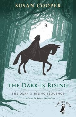 Book jacket for The Dark is Rising by Susan Cooper. The illustration shows the silhouette of a man on a horse riding through the woods.