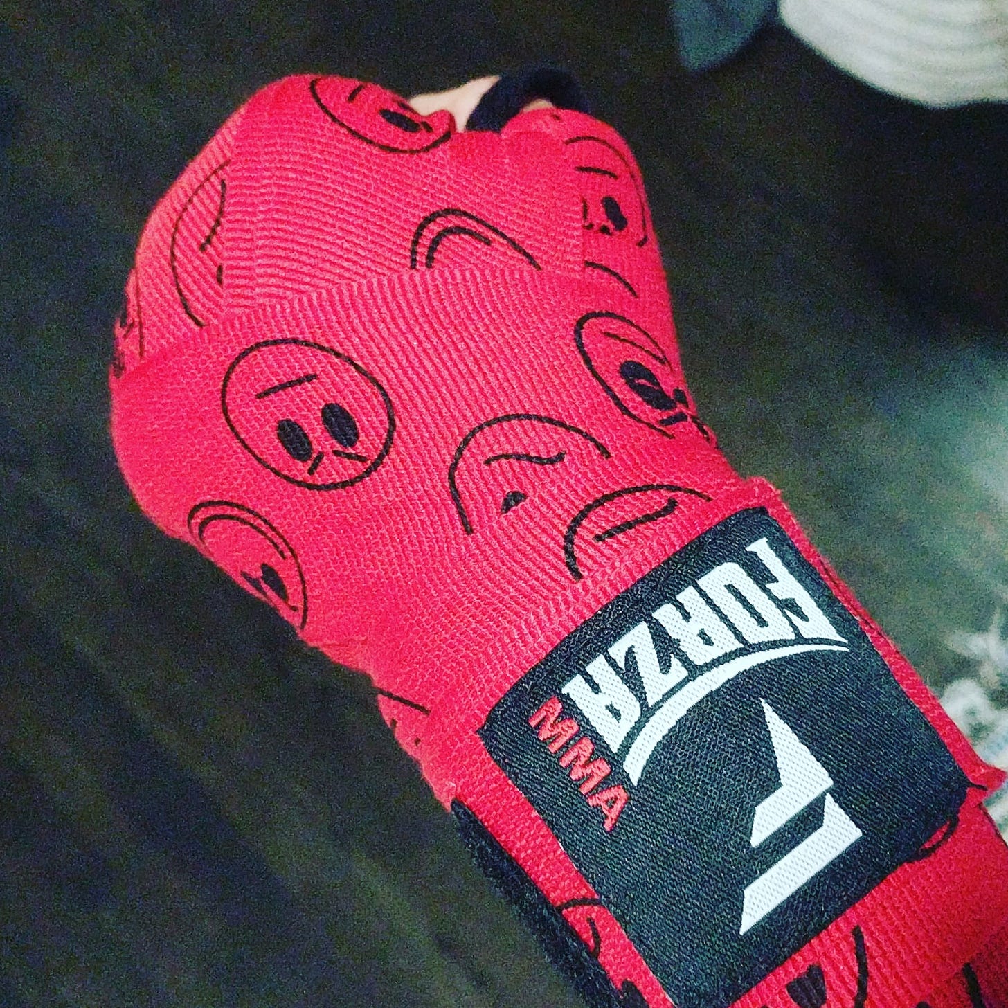 Photograph of a hand wrapped for boxing with red fabric. Photograph of a hand wrapped for boxing with red fabric.