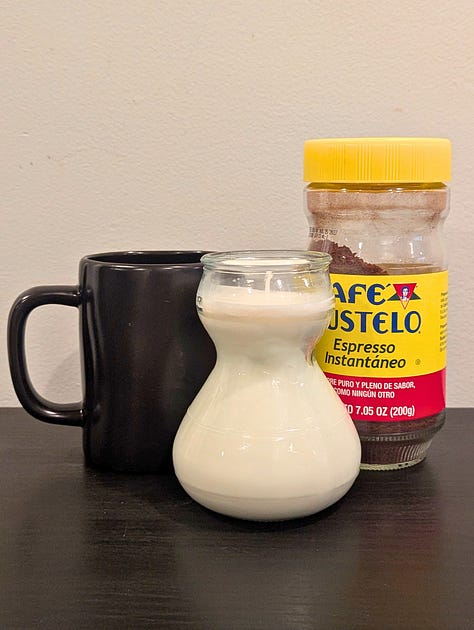 A gallery of candles made by The Chaos Kitchen including a red glass spiced cider, a lavender vanilla kitten mug, and a flower garden teacup.