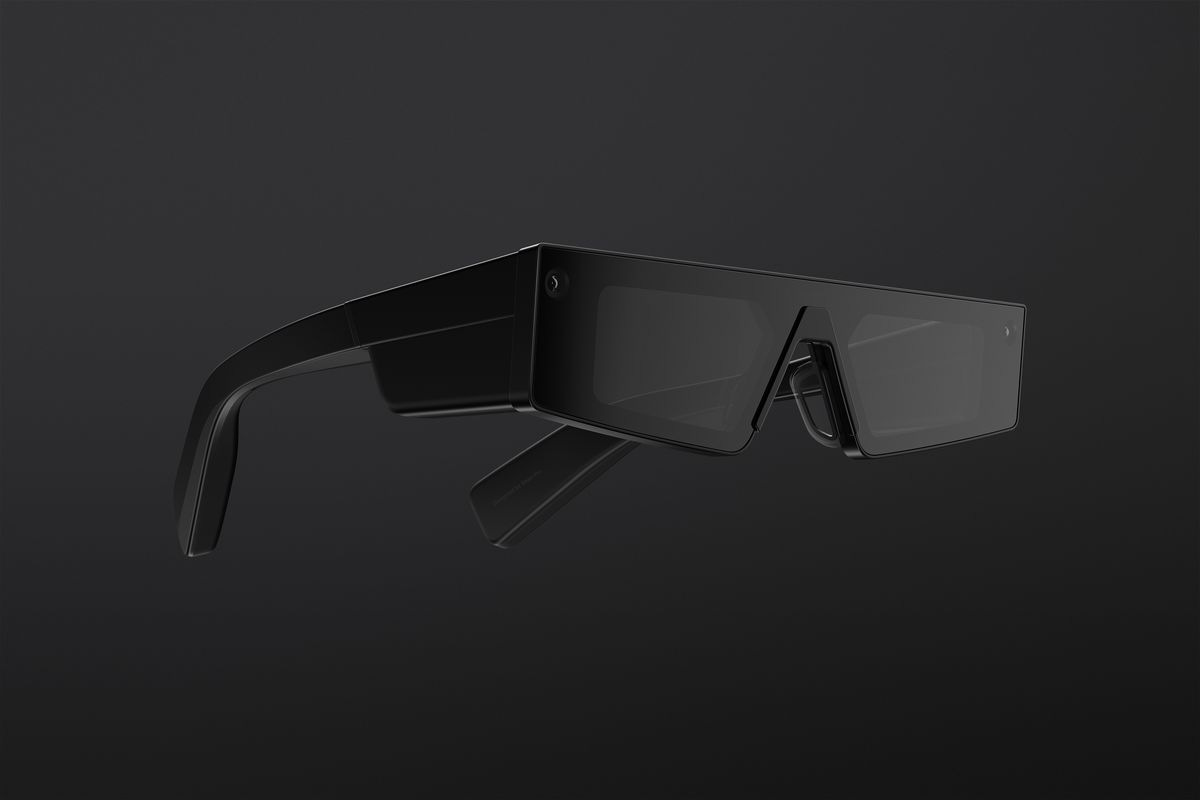 Snap’s fourth generation Spectacles are black, with thick areas at the hinges to house components. They feature angular lenses and cameras beside each hinge.