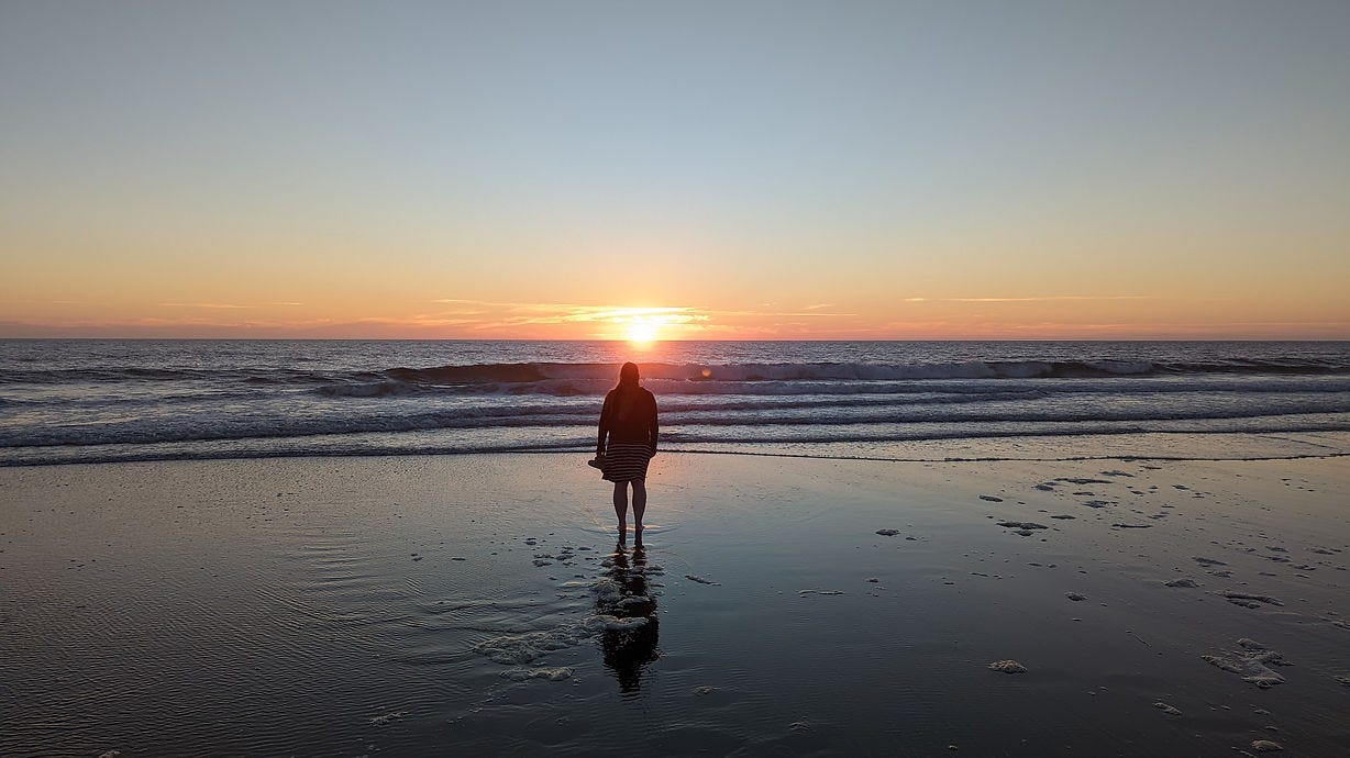 standing on a beach during sunset