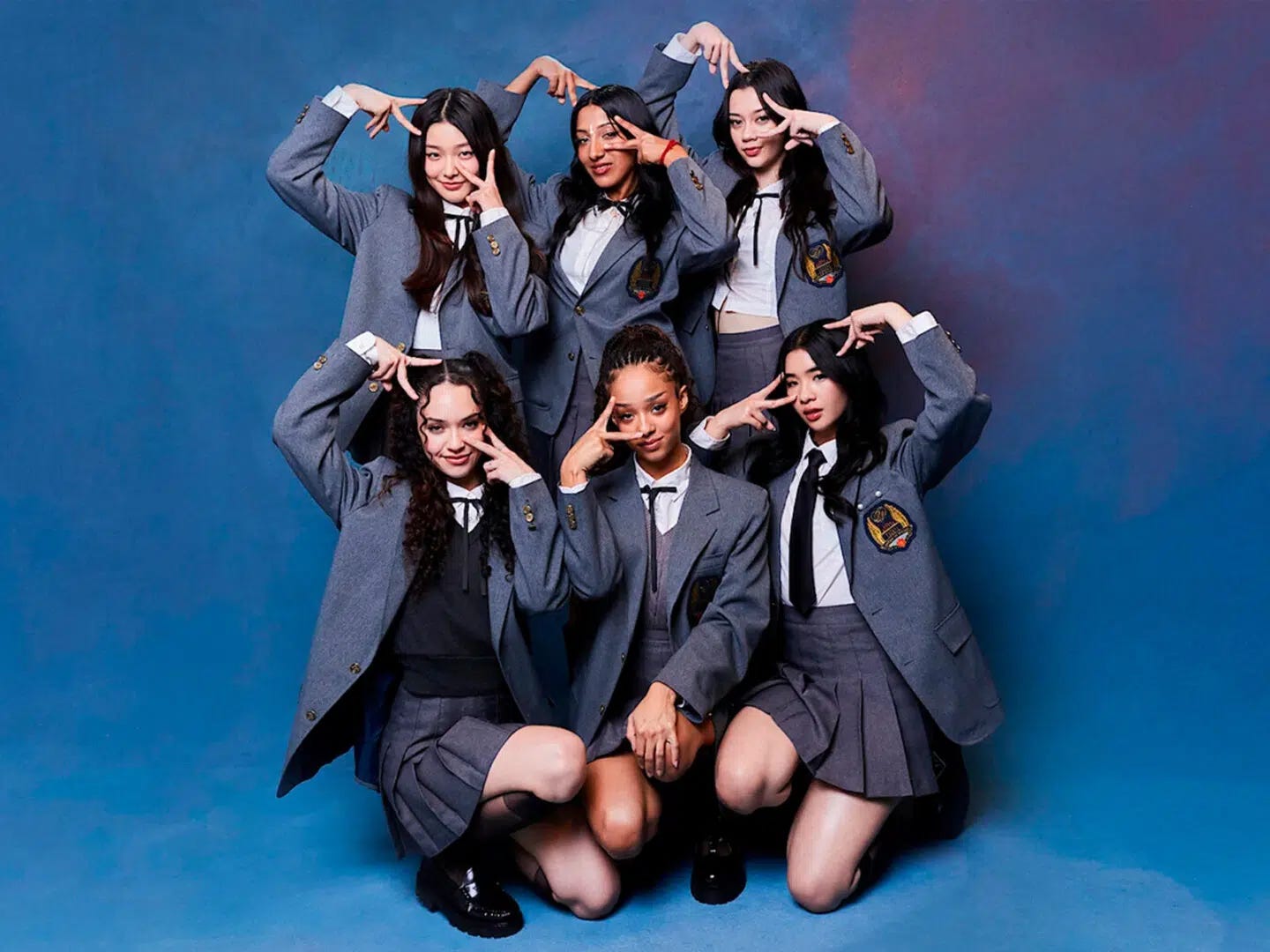 The KATSEYE members posing as a group. They are doing the same finger/hand pose that I am doing in my self-portrait, and they are wearing matching schoolgirl-esque uniforms.