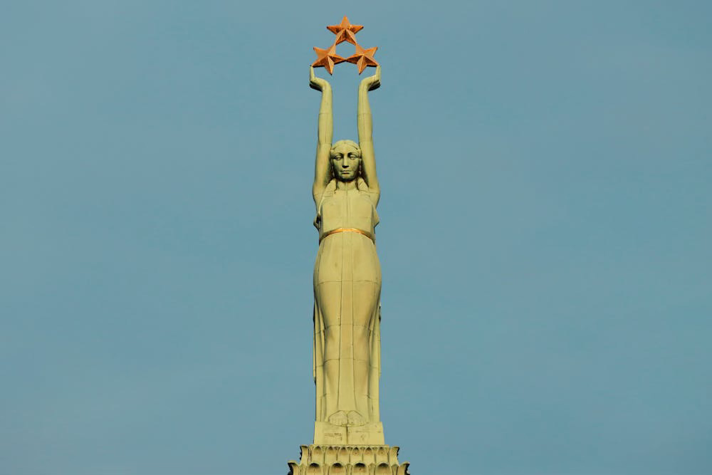A shot of the Freedom Monument in Riga, Latvia, which shows a statue of a woman holding up three red stars