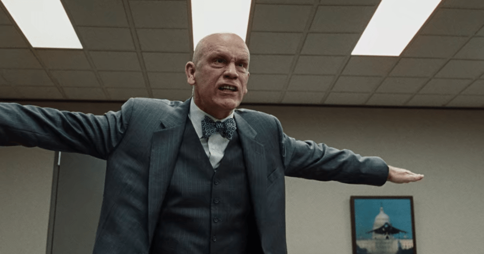 John Malkovich sticking both arms out like he's on a cross, looking furious.