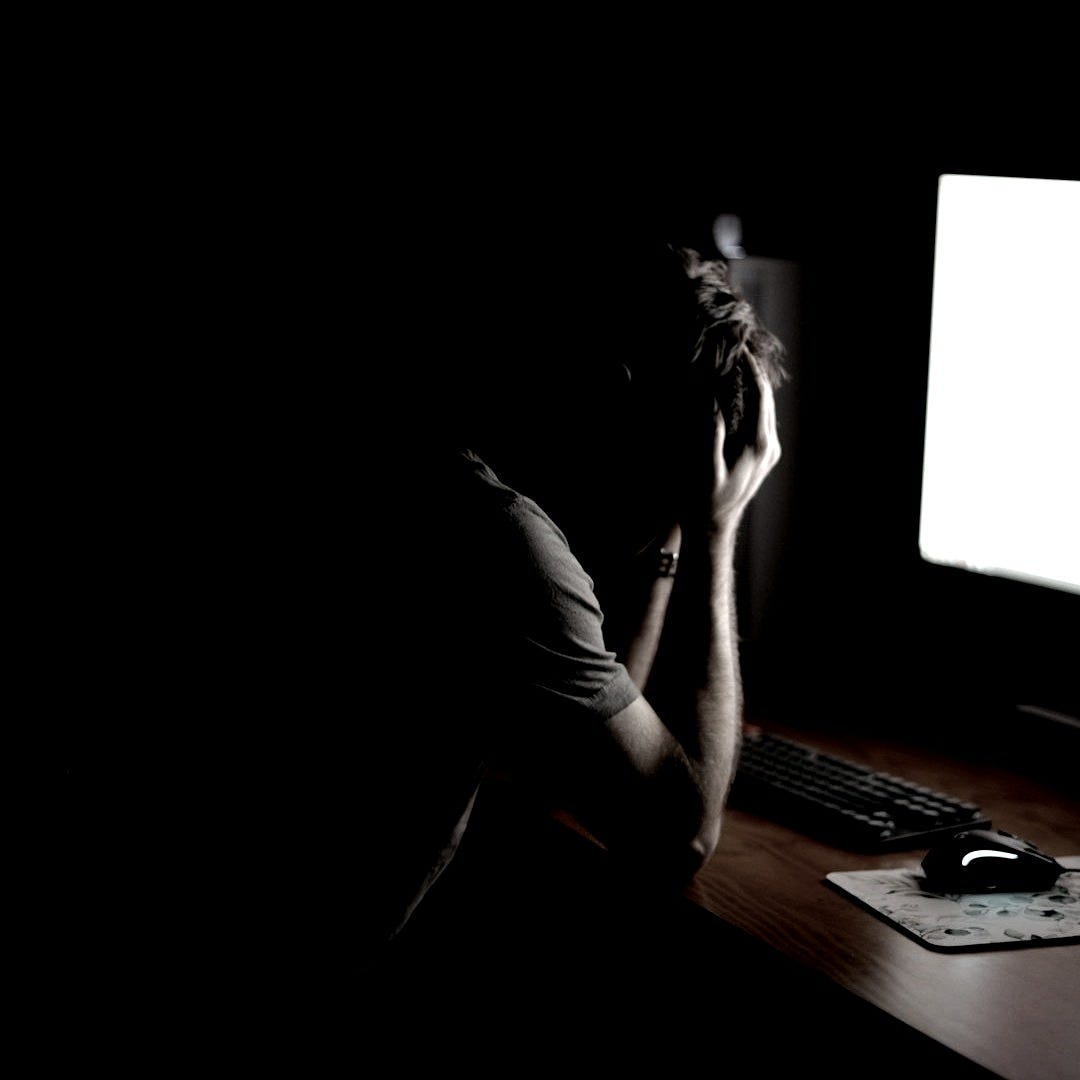 a man sitting at a desk in front of a computer