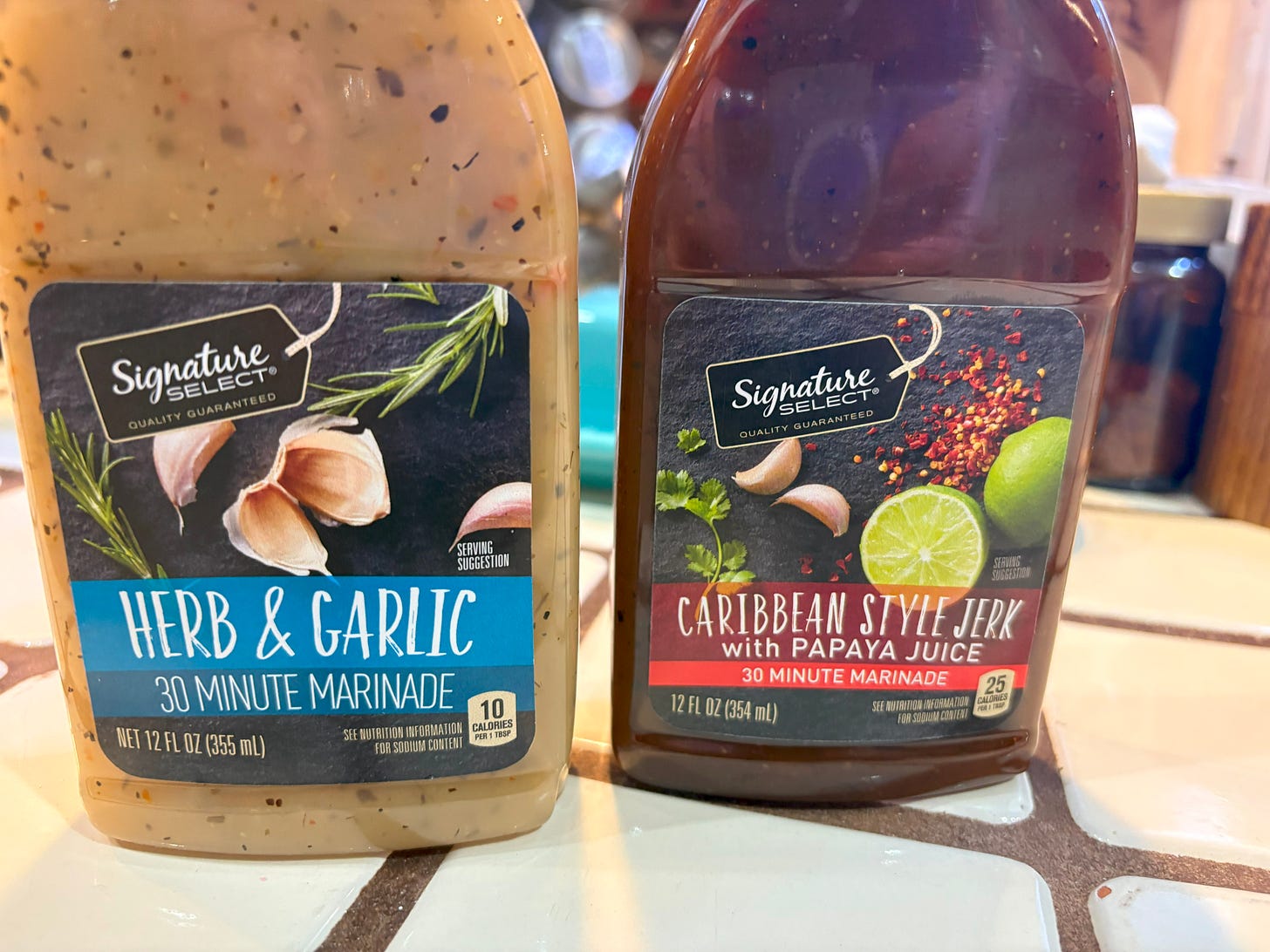 A bottle of garlic sauce and a bottle of jerk sauce