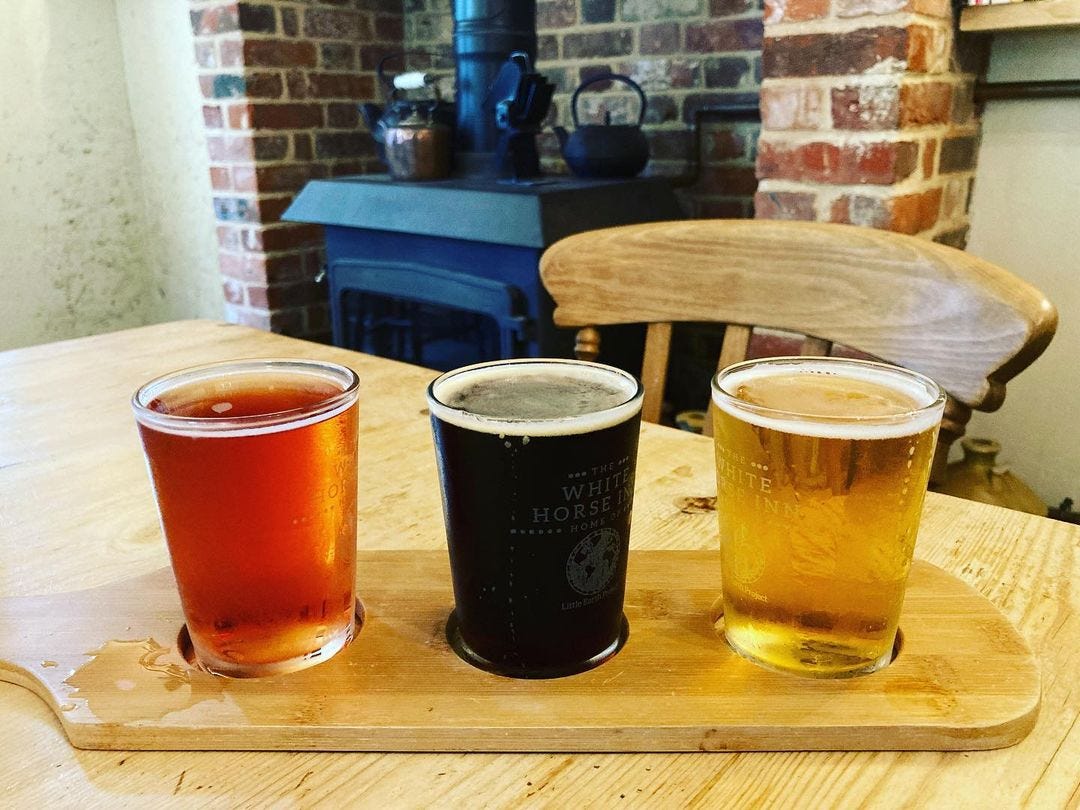 A flight of three beers on a wooden board at the Edwardstone White Horse