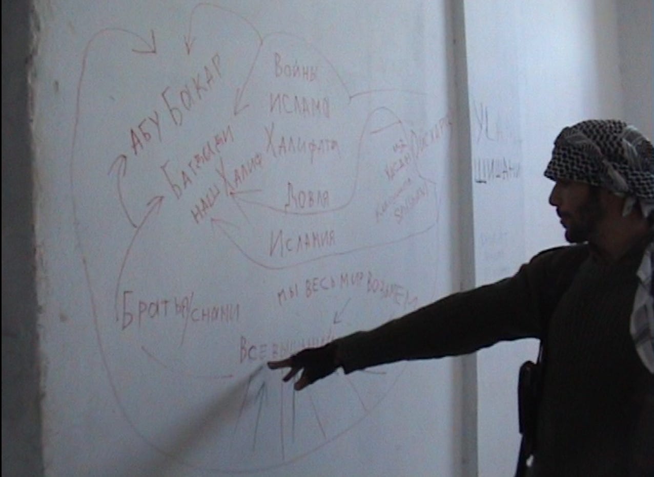 Karim Franceschi in Kobani, 2015, pointing at a map on a wall during the siege.