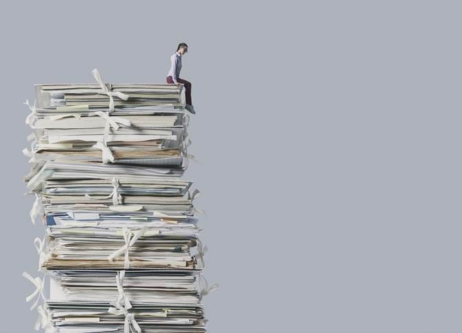 A person sitting on top of a stack of papers

AI-generated content may be incorrect.