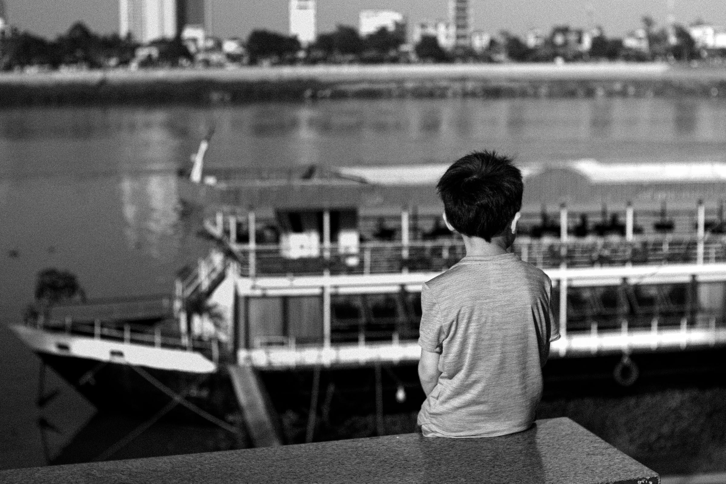 Black and white photo of a person seen from behind in a public place in Cambodia, illustrating daily life and the encounters experienced during our mission journey.