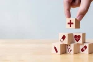 Businessman hand arranging wood block stacking with icon healthcare medical, Insurance for your health concept