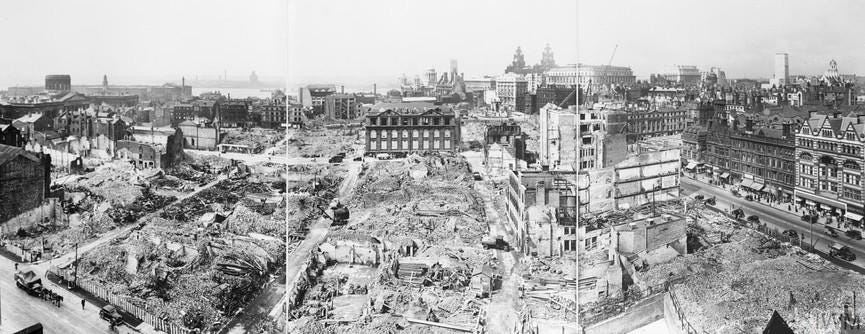 A panoramic view of the city of Liverpool, showing bomb damage received after an air raid. The Liver Building can be clearly seen just to the right of centre, and the River Mersey is just visible to the left of the photograph.