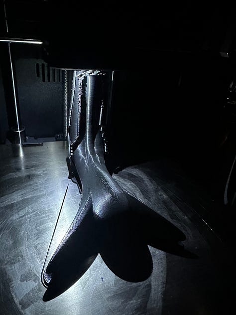A custom 3D printer designed to look like solar punk, with black 3D printed anatomy models of reproductive organs.