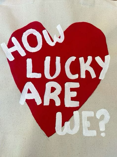 This may contain: a red heart with the words how lucky are we?