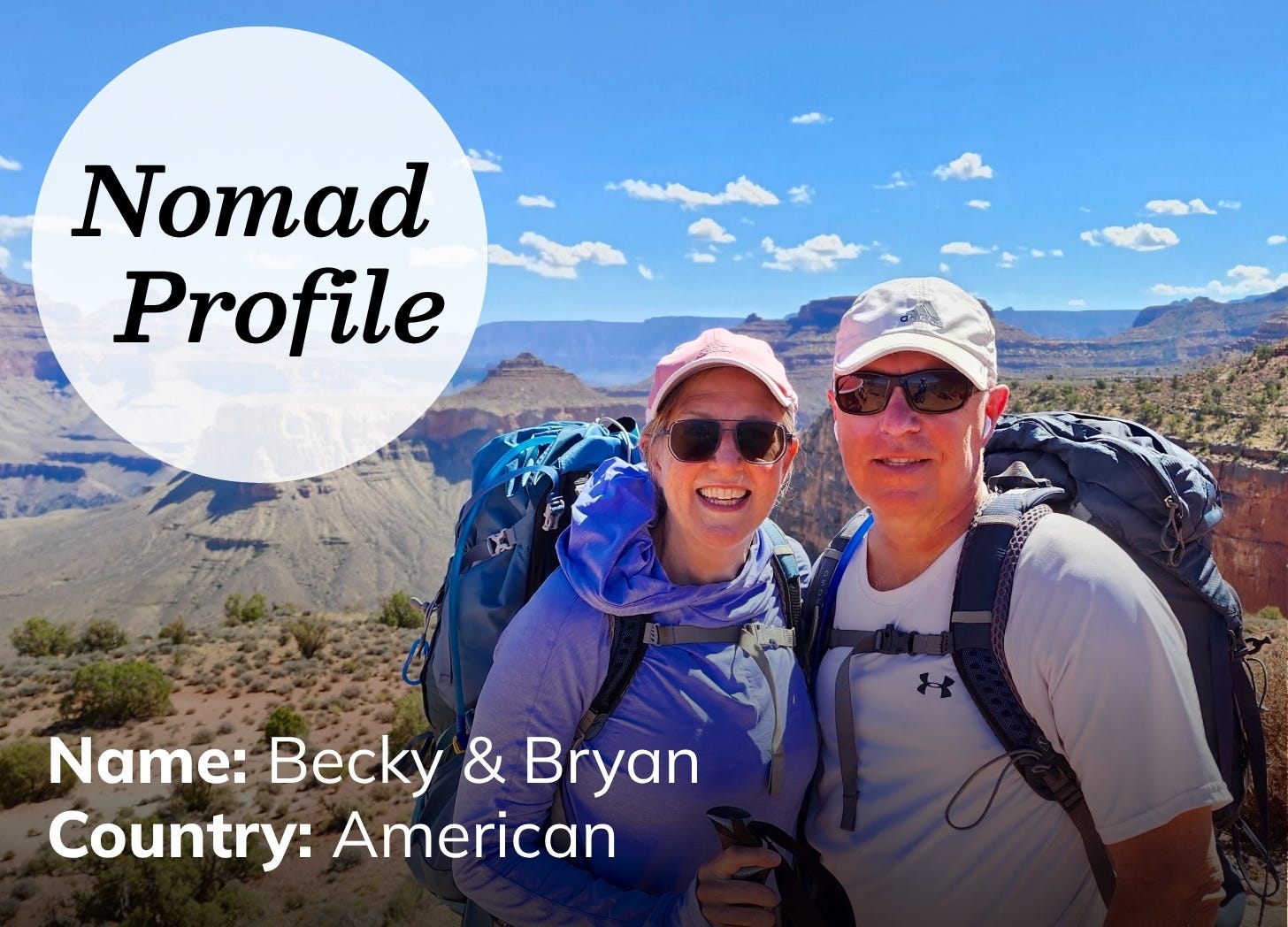 A white man and woman are outfitted in hiking gear, including backpacks, sunglasses, and baseball caps. They are  smiling at the camera and posing in front of a dramatic canyon and blue sky.