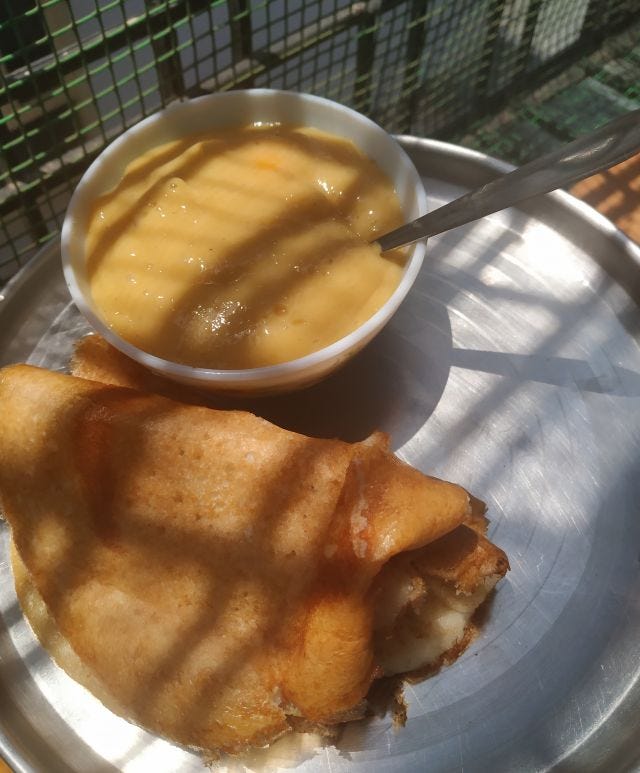 A plate of dosas with a bowl of yellow paste type food.
