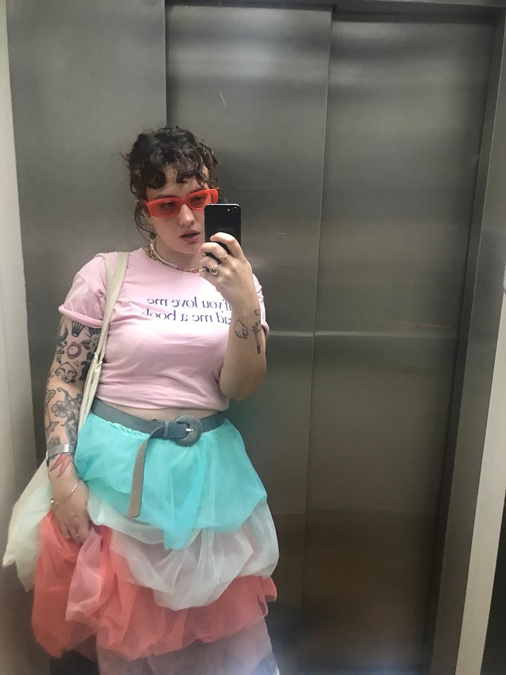 Left: Larissa in a multicolored pastel tutu-esque skirt, light pink t shirt, and orange sunglasses. Right: Larissa in a dramatic seafoam eye look and black choker..
