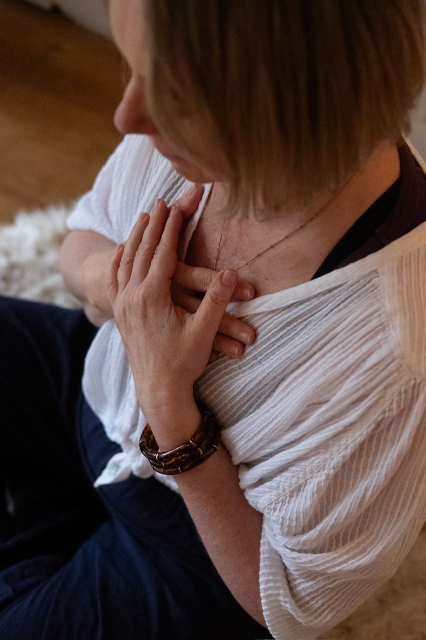 A woman in quiet rest, hands folded against her chest A woman in quiet rest, hands folded against her chest