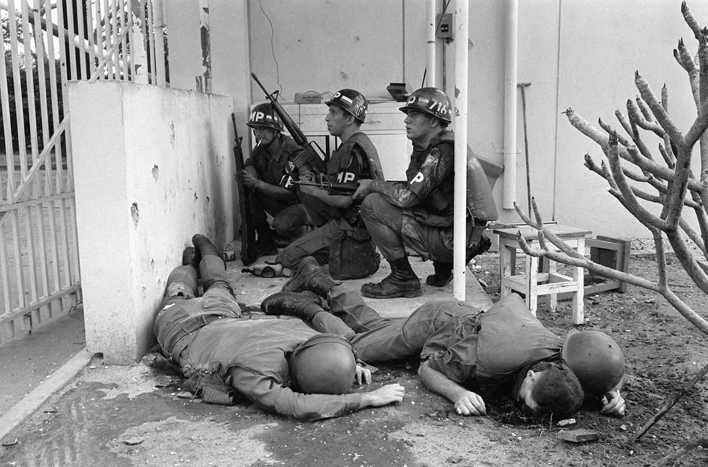 January 31, 1968, Saigon: U.S. military police take cover at the U.S. Consulate entrance, with fallen soldiers nearby, following the Viet Cong's audacious invasion of the embassy compound on the Tet Offensive's first day. January 31, 1968, Saigon: U.S. military police take cover at the U.S. Consulate entrance, with fallen soldiers nearby, following the Viet Cong's audacious invasion of the embassy compound on the Tet Offensive's first day.
