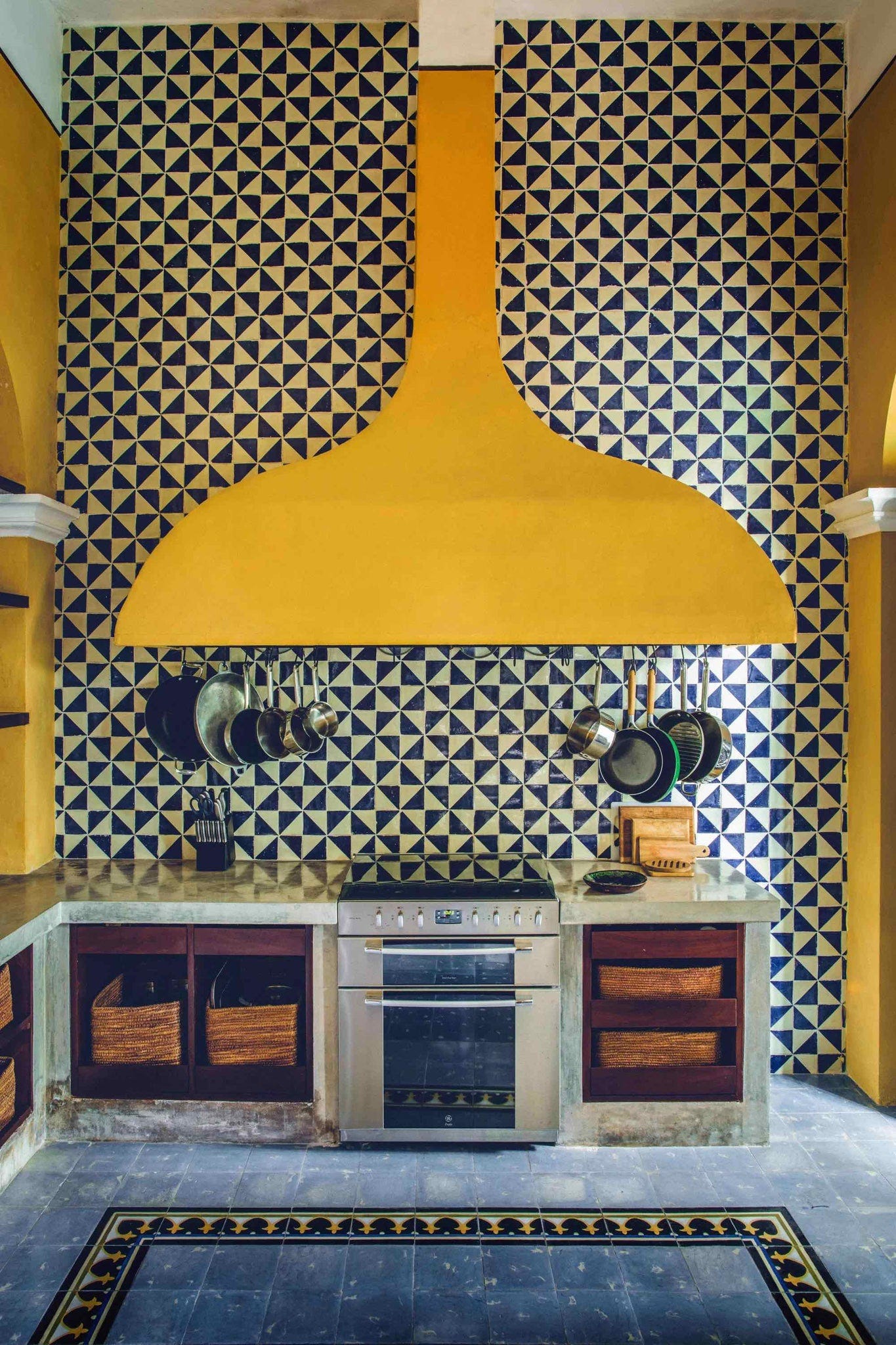a kitchen with a stove and pots from the ceiling