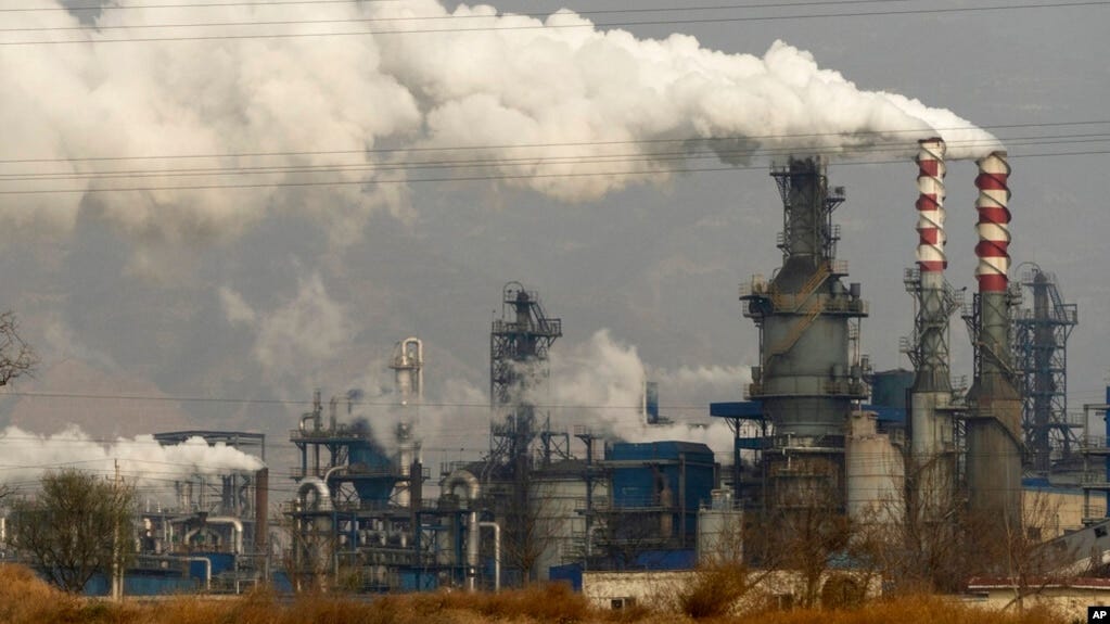 FILE - In this Nov. 28, 2019, file photo, smoke and steam rise from a coal processing plant in Hejin in central China's Shanxi Province. 