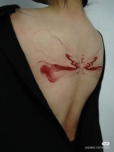This may contain: the back of a woman's neck with red ink on it and an abstract design