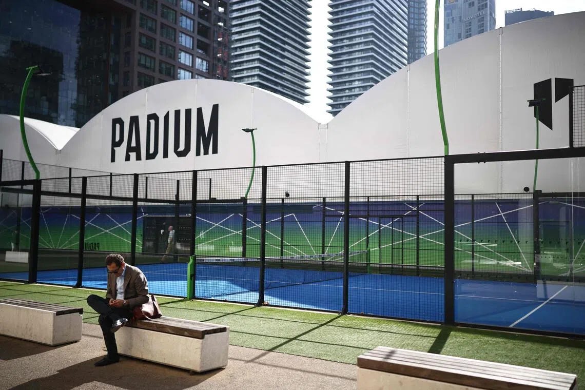 A person relaxes beside a padel court in east London on October 6, 2026. The recent growth in the UK of padel - a cross between tennis and squash played by doubles teams on courts enclosed by glass or wire - has sparked friction in some places, most notably London, where several sites with new or proposed courts have provoked pushback from local communities. (Photo by Henry NICHOLLS / AFP) A person relaxes beside a padel court in east London on October 6, 2026. The recent growth in the UK of padel - a cross between tennis and squash played by doubles teams on courts enclosed by glass or wire - has sparked friction in some places, most notably London, where several sites with new or proposed courts have provoked pushback from local communities. (Photo by Henry NICHOLLS / AFP)