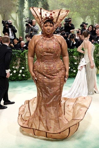 Image may contain Lizzo Person Clothing Footwear High Heel Shoe Adult Camera Electronics Wedding and Hat