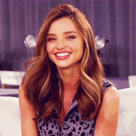 a woman with long hair is smiling and wearing a leopard print top a woman with long hair is smiling and wearing a leopard print top