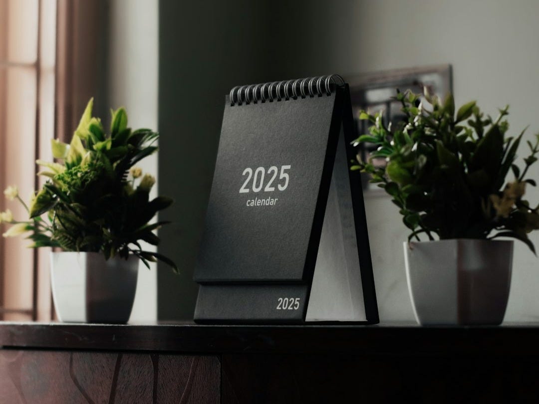 A desk with a calendar and plants on it
