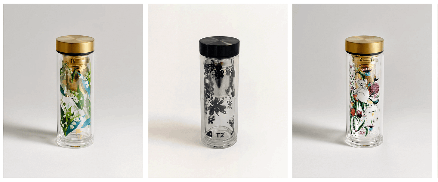 Three clear, double-walled glass tea flasks with screw-on lids, decorated with delicate floral and artistic patterns across their glass surfaces. Gemini assisted with this alt-text.