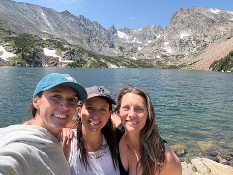 Photos of Meg, Stef, and Emily at a mountain lake. Photo of Emily in a jacket that says "angel of the get through." Photo of Meg flanked by Brandon and Stef sitting close beside each other.