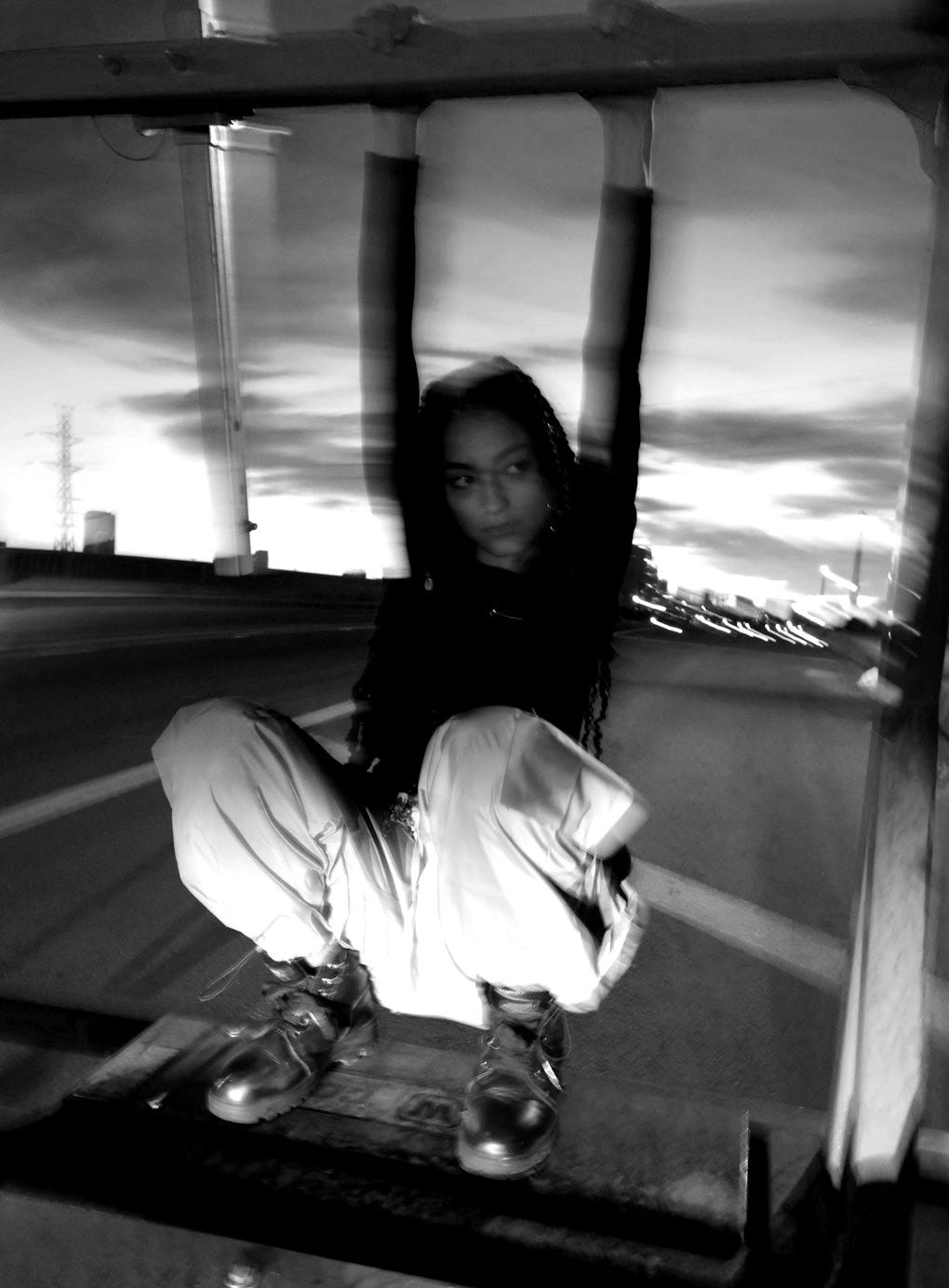 woman in black jacket and white pants sitting on brown wooden bench