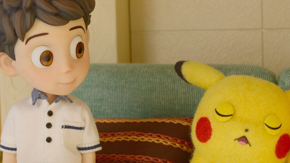 A boy watches his Pokemon sleep.