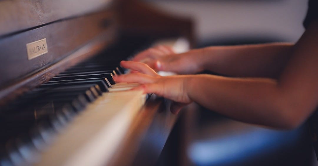 person playing upright piano
