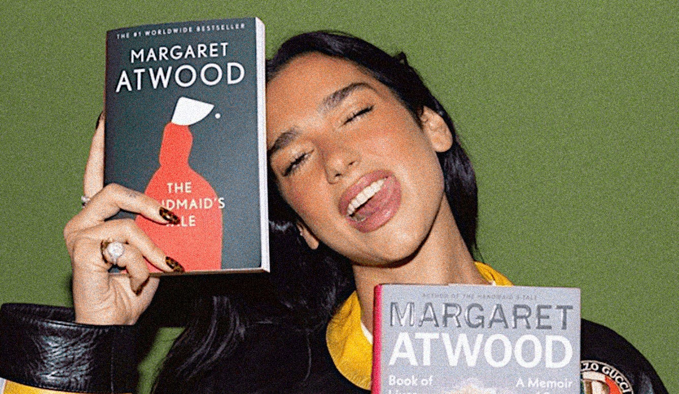 Woman with long dark hair holds Margaret Atwood’s The Handmaid’s Tale beside a second Atwood book.