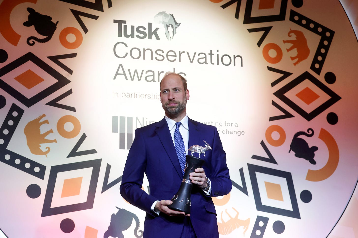Prince William holding an award