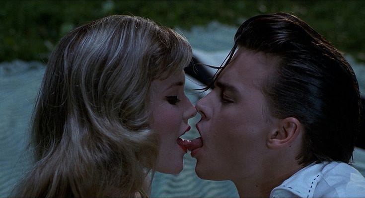 This may contain: a man kissing a woman on the cheek