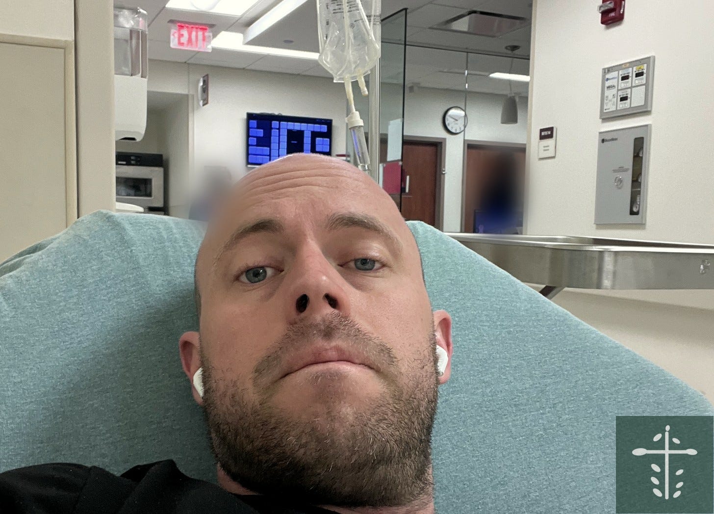 Mike lying on a hospital bed in a busy hospital hallway, looking up at the camera, unsmiling. Mike lying on a hospital bed in a busy hospital hallway, looking up at the camera, unsmiling.