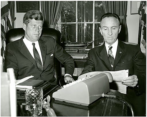 Senator Mike Mansfield and President John F. Kennedy sitting next to each  other at a desk with a typewriter in front of them. · Archives and Special  Collections - Maureen and Mike
