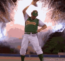 a baseball player wearing a green charcos jersey stands in front of a fireworks display a baseball player wearing a green charcos jersey stands in front of a fireworks display